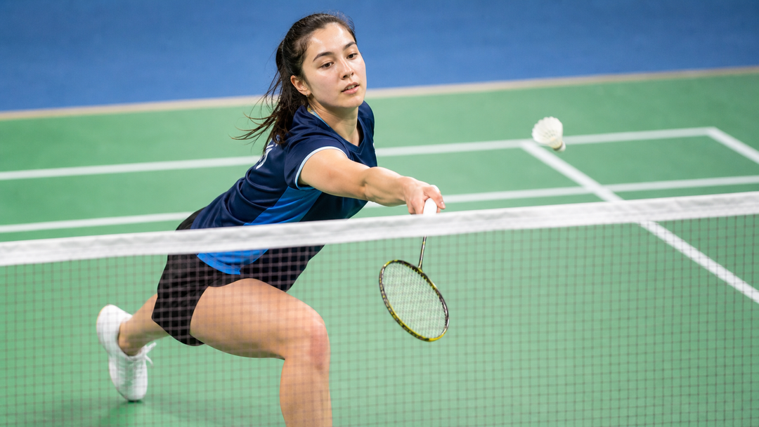 Badminton player lunging forward for a controlled net shot
